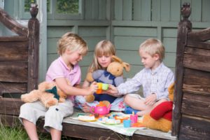Jugar en grupo. Foto varios niños jugando con muñecas.